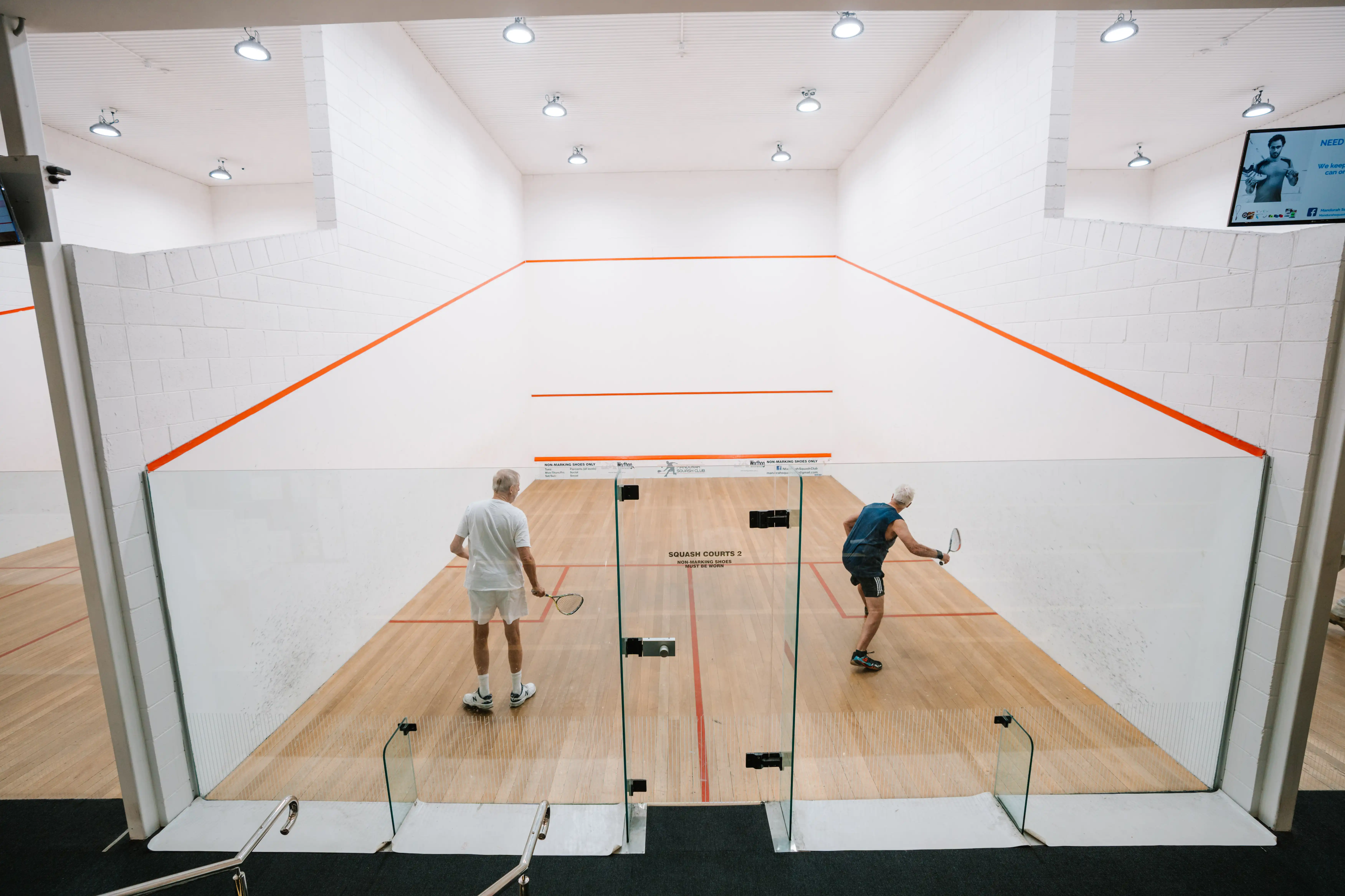 Aerial image of two people playing squash.